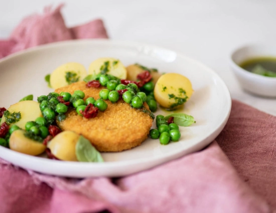 Cutlet with peas, new potatoes and sundried tomatoes with vegetable pesto