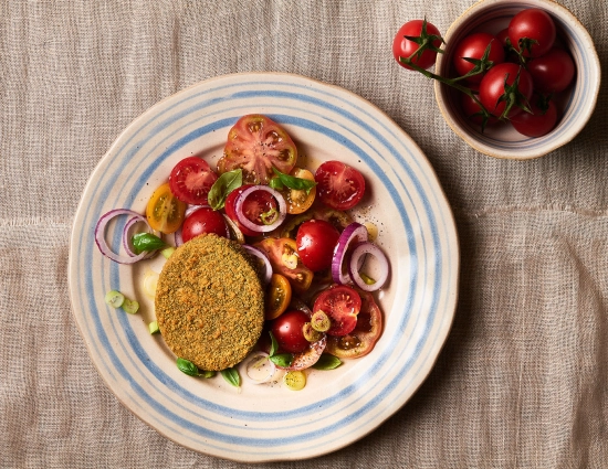 Cotoletta con spinaci con insalata di pomodori, cipolla rossa, cipollotti e basilico