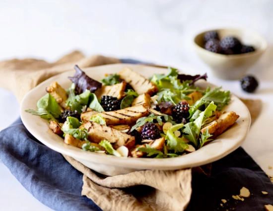 Tasty tagliata on mesclun with blackberries and almonds