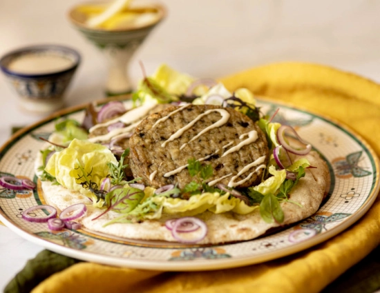 Pita bread with aubergine burger, mesclun and tahini sauce