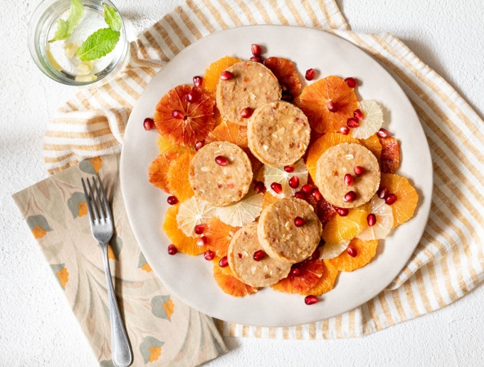 Mini cakes on citrus fruit carpaccio and pomegranate