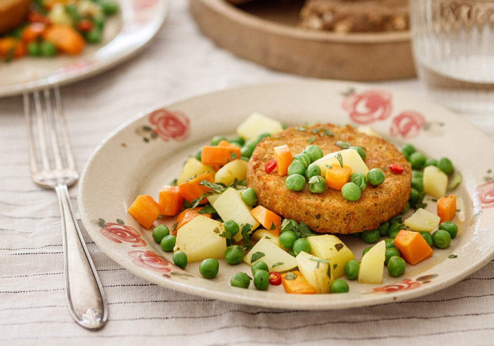Chickpea burger with carrots, potatoes and mildly spicy peas