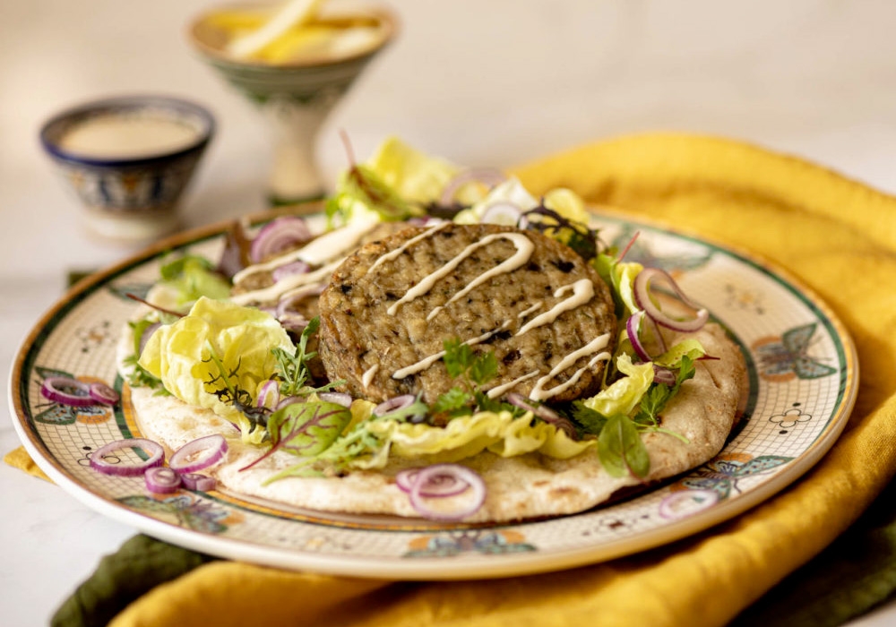 Pita bread with aubergine burger, mesclun and tahini sauce